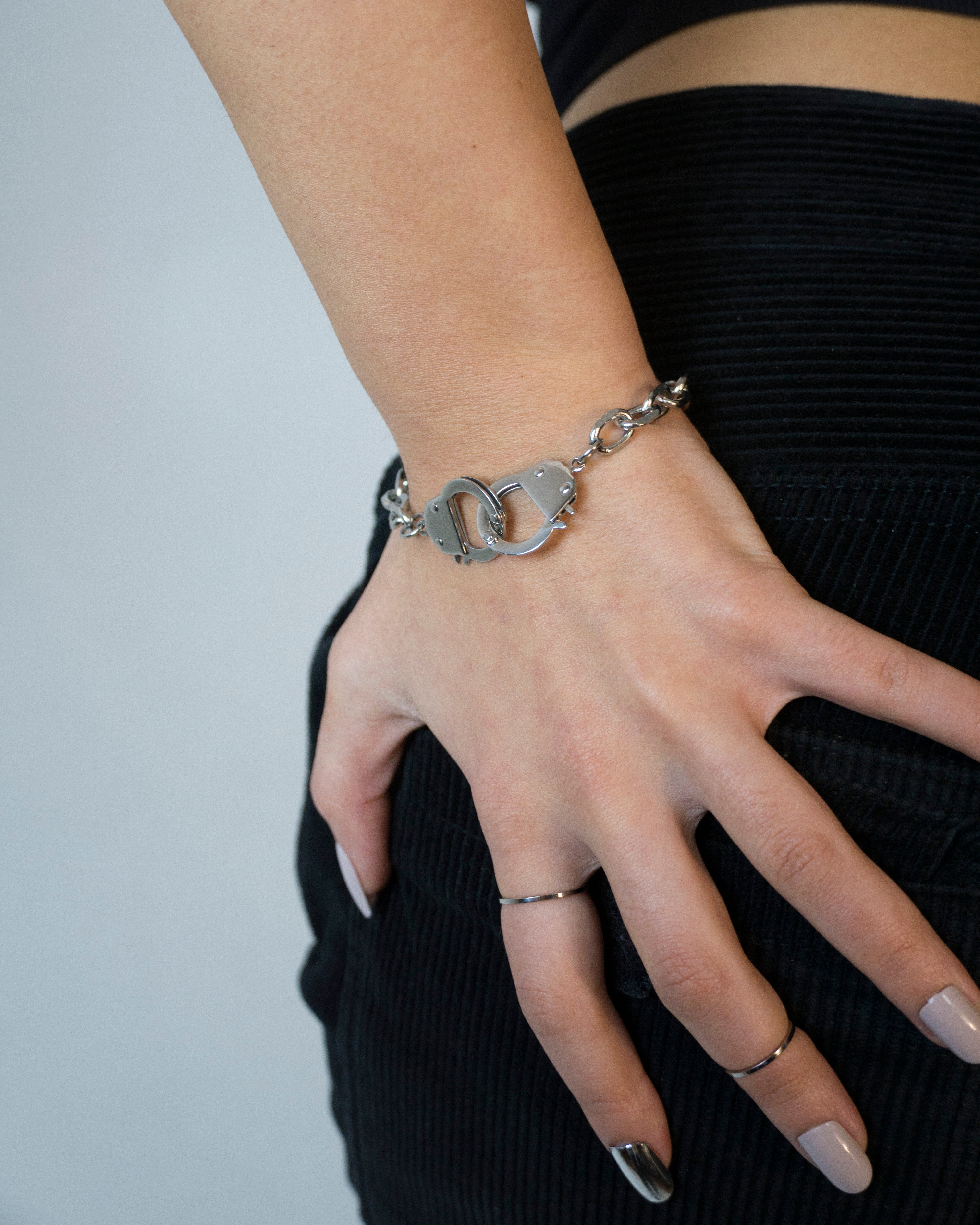 Size adjustable bracelets with handcuff pedants.  Minimalist bracelets featuring handcuff pendants. Elevate your style with minimalist bracelets, perfect for daily wear and layering. Crafted from high-quality stainless steel and available in silver color  Material: Surgical steel, Color: Silver. Size adjustable 16-20cm in length.  | water-resistant, no-tarnishing, hypoallergenic |