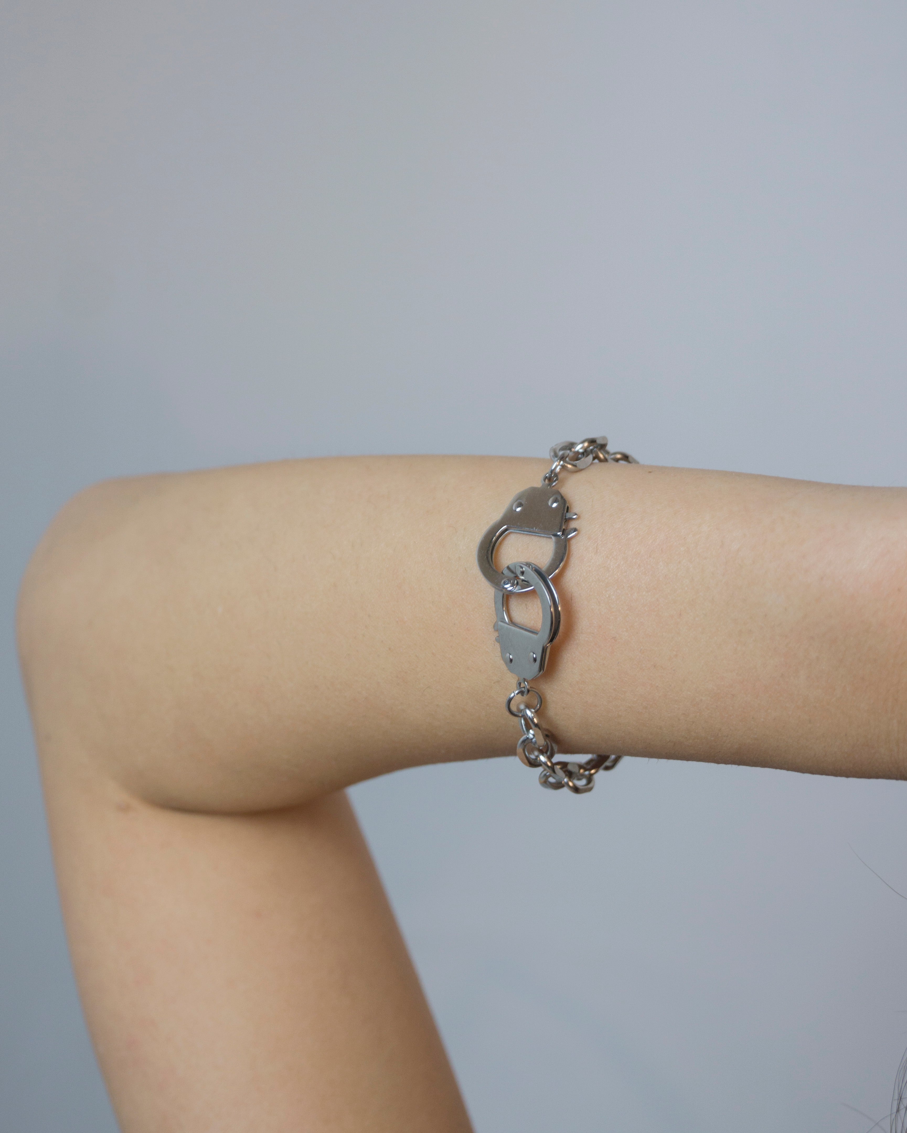 Size adjustable bracelets with handcuff pedants.  Minimalist bracelets featuring handcuff pendants. Elevate your style with minimalist bracelets, perfect for daily wear and layering. Crafted from high-quality stainless steel and available in silver color  Material: Surgical steel, Color: Silver. Size adjustable 16-20cm in length.  | water-resistant, no-tarnishing, hypoallergenic |