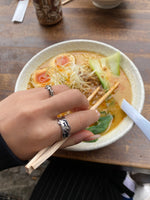 Load image into Gallery viewer, Open ring resembling the silhouette of waves.  Irregular texture of the surface inspired by the bold silhouette of a wave crashing. Elevate your style with our minimalist ring, perfect for daily wear and layering. Crafted from high-quality titanium and available in silver color.  Material: Titanium  | water-resistant, no-tarnishing, hypoallergenic |
